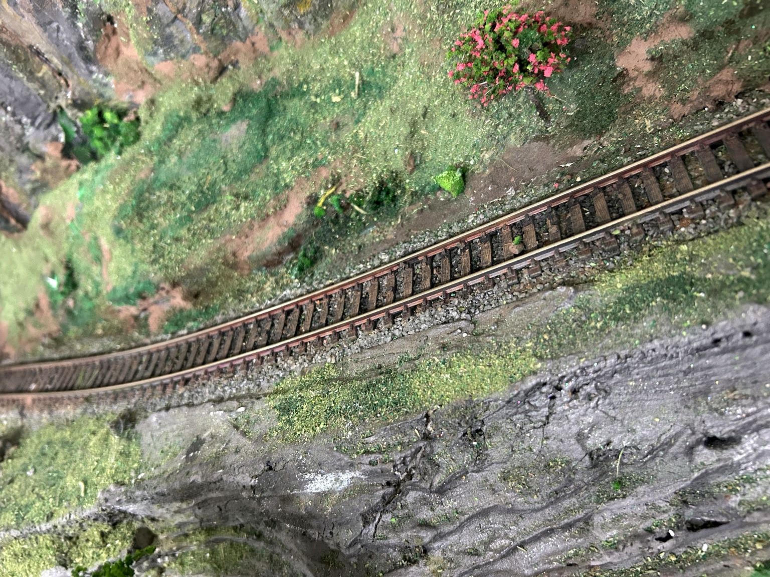 Trecho de trilho concluído com lastro e paisagismo
